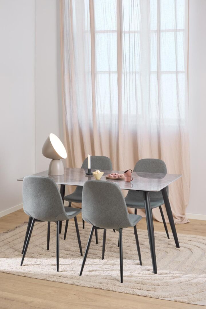 Celia eetkamerstoel (set van 4) aan eettafel met lamp en decoratie.