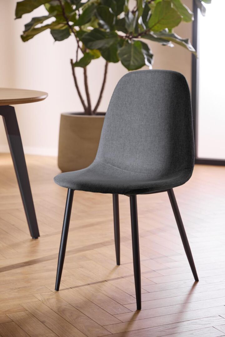 Celia eetkamerstoel: Grijze gestoffeerde stoel met zwarte poten.