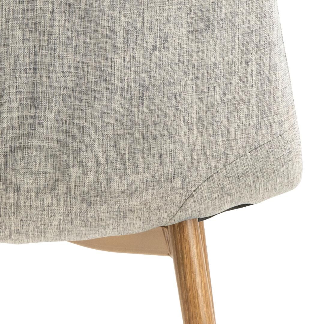 Close-up Celia eetkamerstoel: grijze stoffen bekleding en houten poten.
