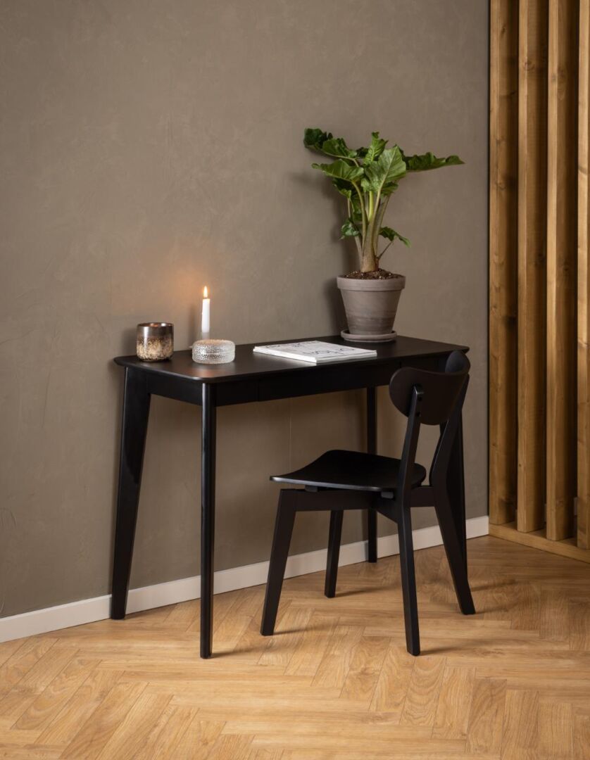 Zwarte Roxby eetkamerstoel bij een zwart bureau met plant en kaars.
