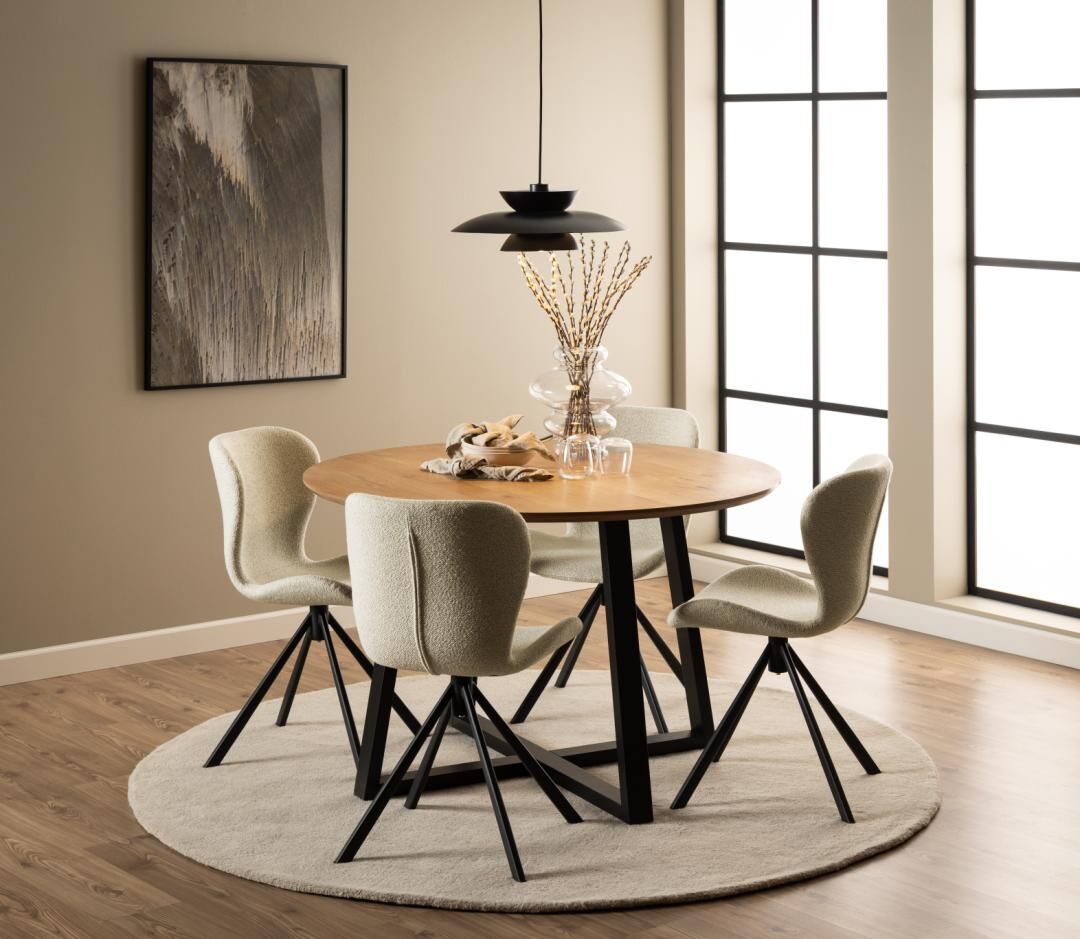 Ronde eettafel met vier Batilda -A1 eetkamerstoelen, vaas en moderne hanglamp.