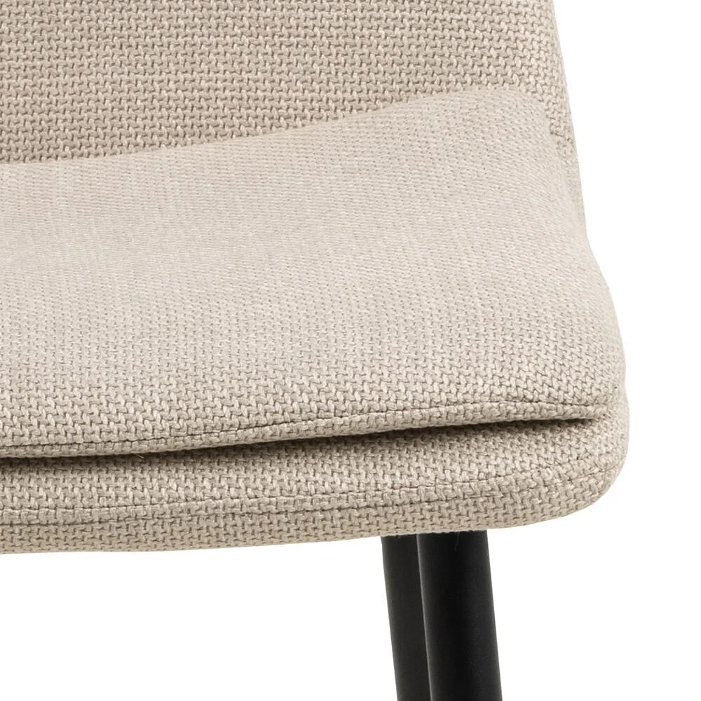Becca eetkamerstoel: Detailopname van de beige zitting met zwarte poten.