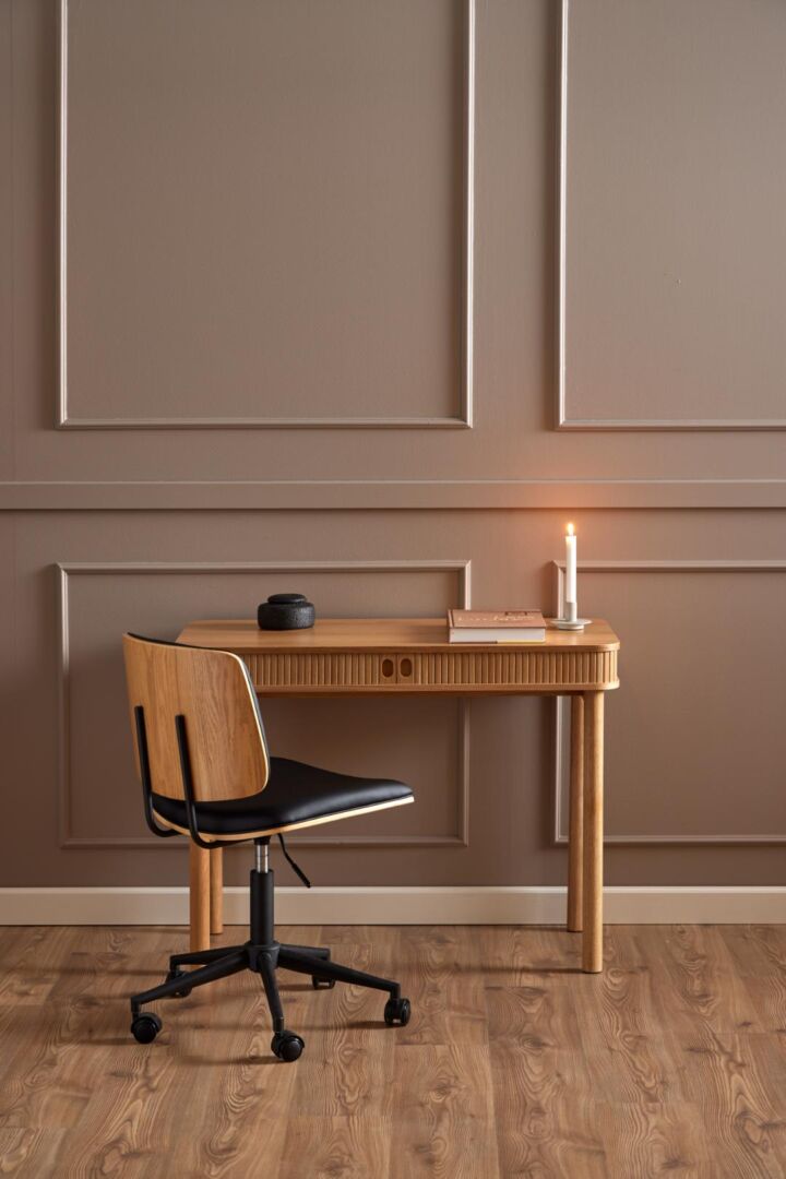 Owen bureaustoel voor houten bureau met paneelwand achtergrond.