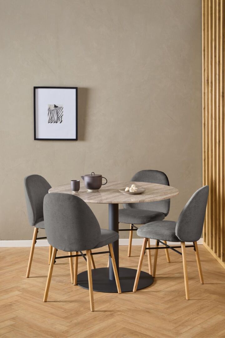 Ronde eettafel met vier Sophia eetkamerstoelen, theepot en decoratie.
