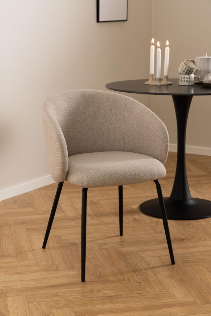 Eetkamerstoel Eleanor met armleuning: beige stoffen stoel met zwarte poten.