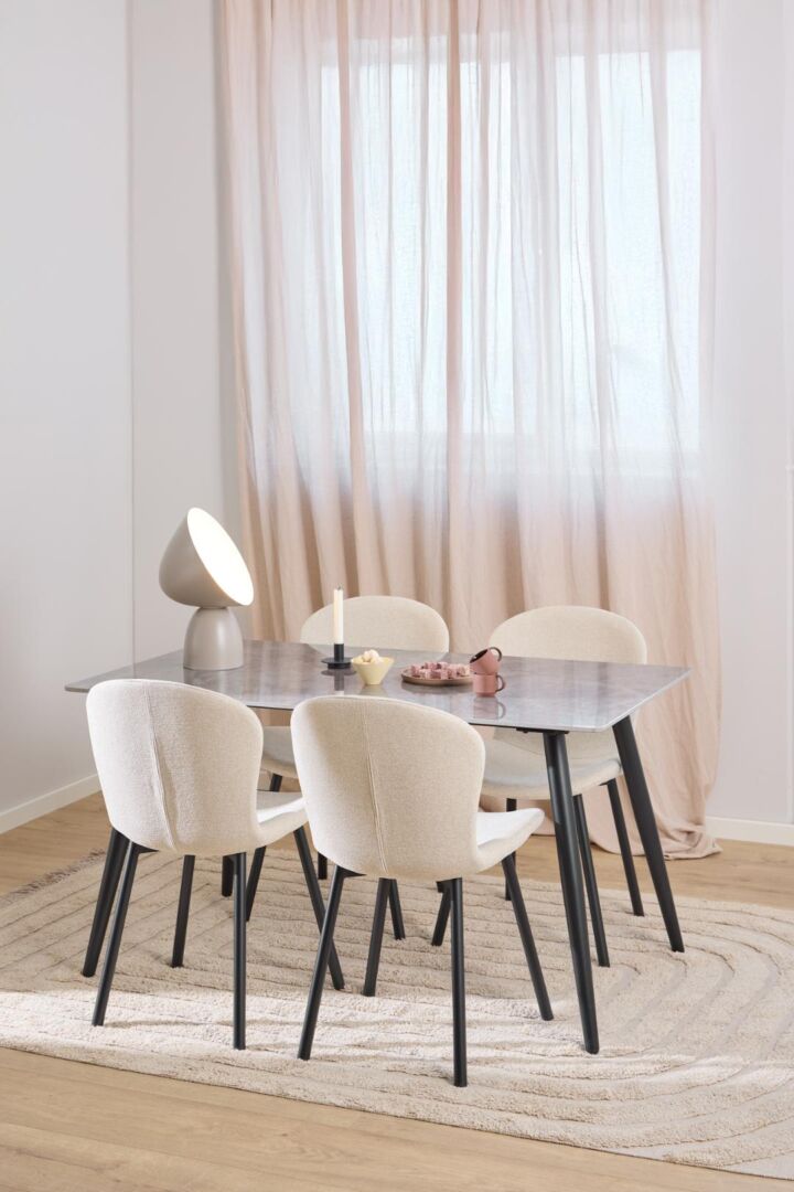 Esra eetkamerstoel (set van 2) aan eettafel met lamp, kaars en accessoires.