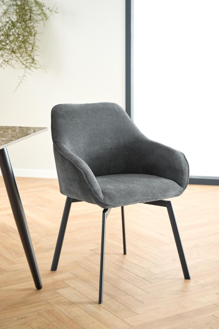 Clara eetkamerstoel met armleuning: Grijze gestoffeerde stoel met zwarte metalen poten.