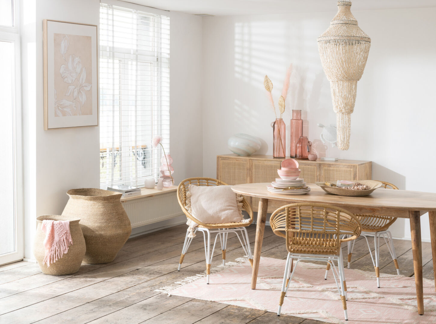 Buitenstoel Jeanne Metaal Rotan Naturel Wit in lichte eetkamer setting met houten tafel en decoratieve accessoires.