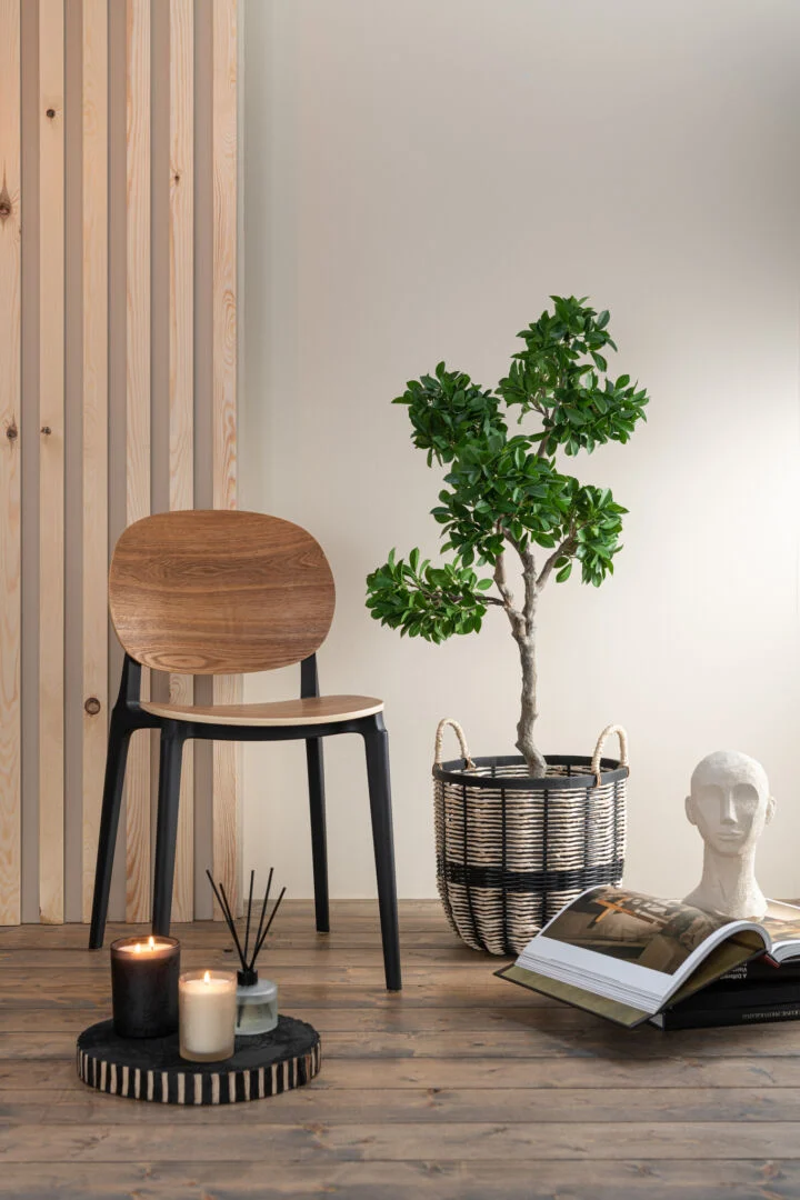Stoel Basic Polyester Fineer Naturel van Nieuwe Sfeer: Houten zitting met zwart frame, sfeervolle interieurfoto.