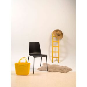 Workliving Houten Eetkamerstoel Zwart Eiken: Zwarte houten eetkamerstoel naast gele tas en ladder met hoed.