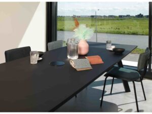 Workliving Bo Eetkamerstoel Fluweel Bosgroen aan zwarte eettafel met accessoires. Nieuwe Sfeer.
