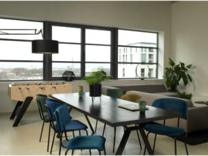 Workliving Bo RS Society Bouclé Shiitake: Moderne eetkamer met donkere houten tafel en blauwe stoelen.