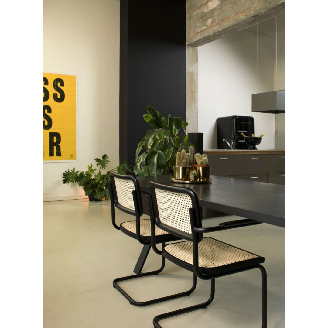 Workliving Bas Armstoel Rotan Walnoot Chroom: Stijlvolle rotan armstoel in een moderne setting.