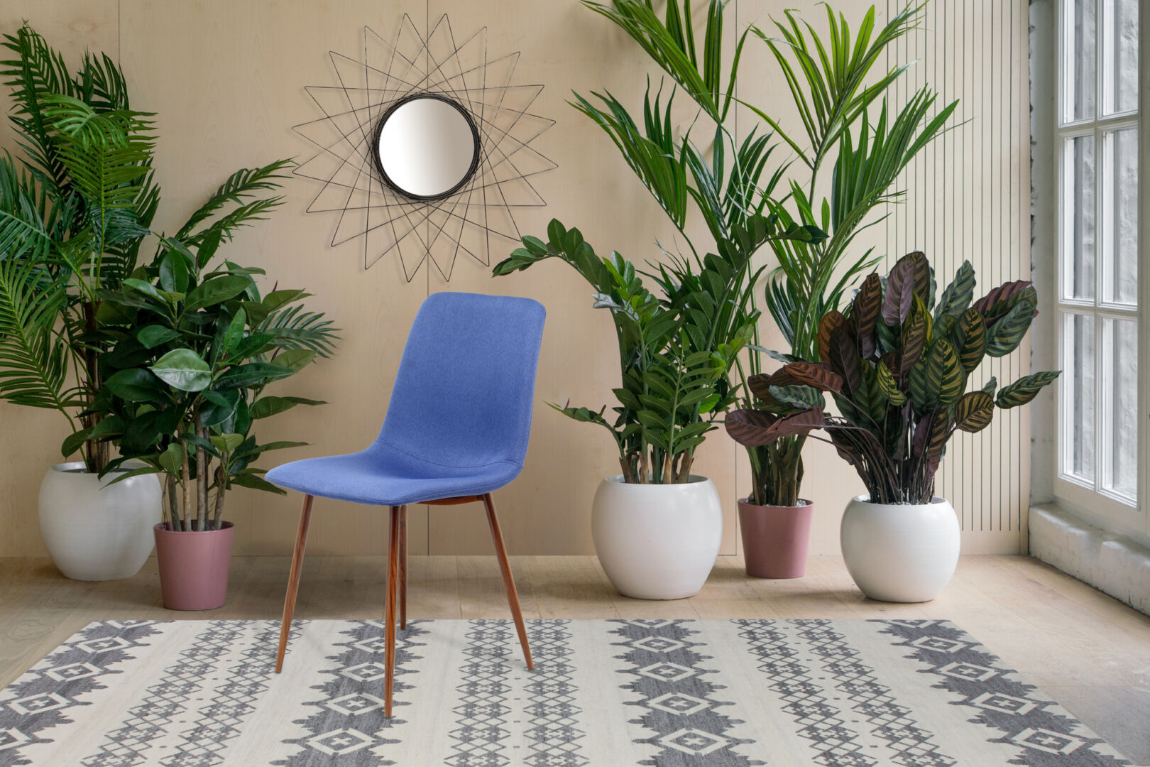 Stoel Maggie Blauw van Nieuwe Sfeer: blauwe stoel in een groene omgeving met planten.