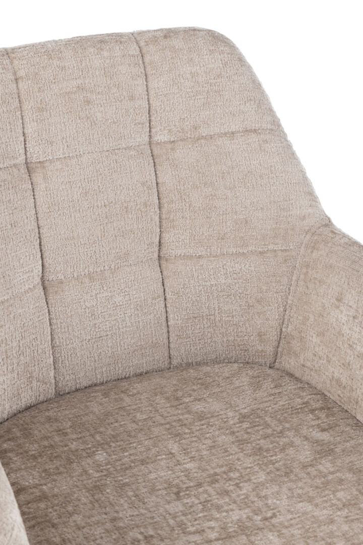 Stoel Louna: Detailopname van een beige gestoffeerde stoel met vierkante capitonnering.