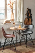 Stoel Loft Leer Metaal Zwart in gezellige eethoek met ronde tafel en decoratieve accessoires | Nieuwe Sfeer