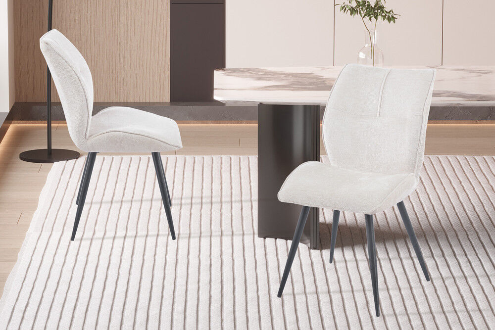 Eetkamerstoel Faye Ecru Stof: Stijlvolle ecru eetkamerstoelen met zwarte metalen poten op een gestreept vloerkleed.