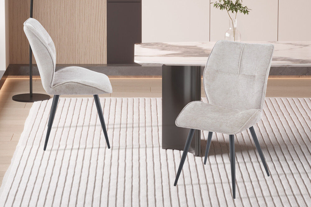 Eetkamerstoel Faye Zand Stof: Beige stoffen stoel met zwarte poten op gestreept vloerkleed.