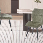 Eetkamerstoel Faye Groen Stof: Groene stoffen eetkamerstoelen met zwarte poten op gestreepte vloerkleed.