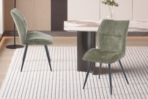 Eetkamerstoel Faye Groen Stof: Groene stoffen eetkamerstoelen met zwarte poten op gestreepte vloerkleed.