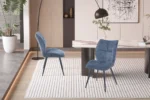 Eetkamerstoel Faye Blauw Stof: Twee blauwe stoffen eetkamerstoelen op een kleed.