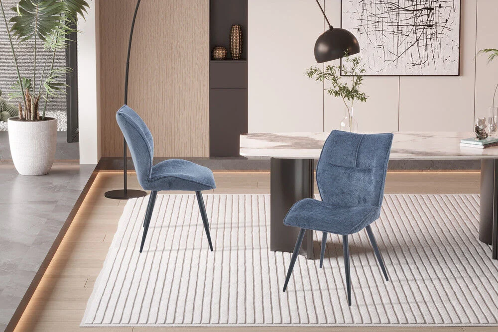 Eetkamerstoel Faye Blauw Stof: Twee blauwe stoffen eetkamerstoelen op een kleed.