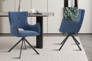 Eetkamerstoel Billy Blauw Draaibaar: Blauwe gestoffeerde stoel met zwarte draaivoet aan een moderne eettafel.