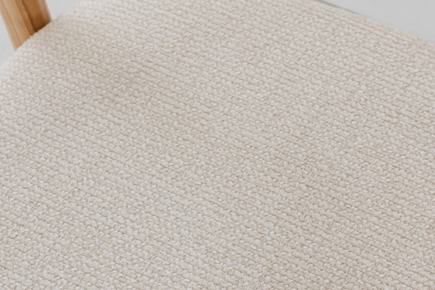 Eetkamerstoel Claire Essenhout Naturel Beige: Close-up van de beige stoffen zitting en het houten frame.