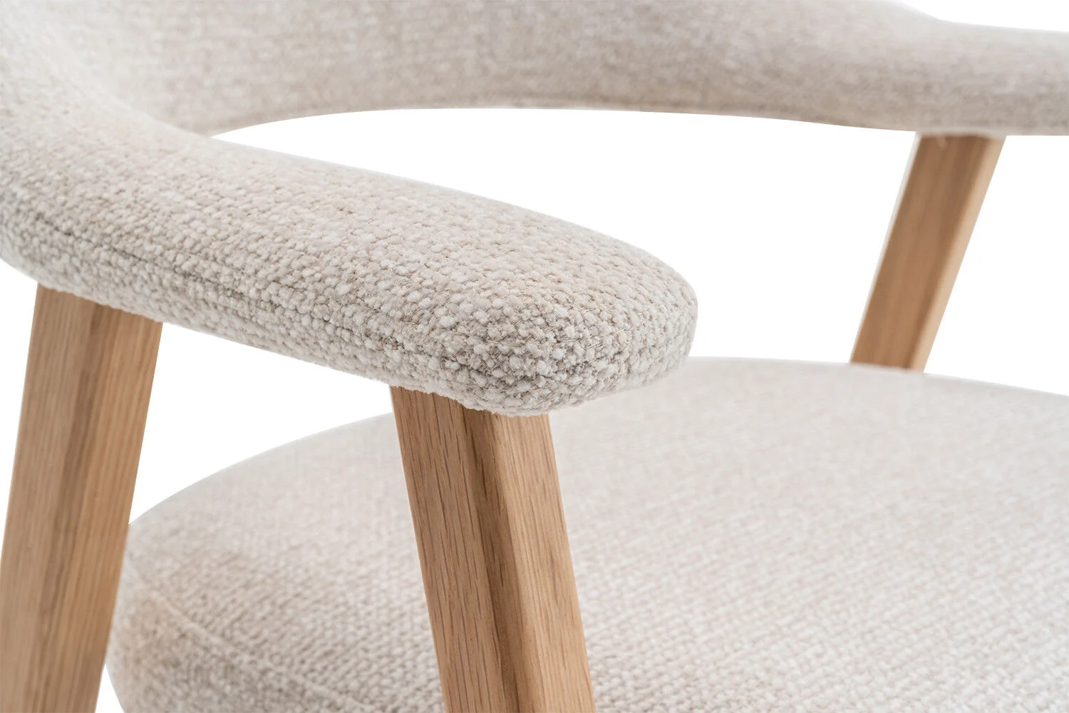Eetkamerstoel Coralie Massief Eiken Beige: Detailopname van de beige stoffen zitting en armleuning met massief eiken frame.