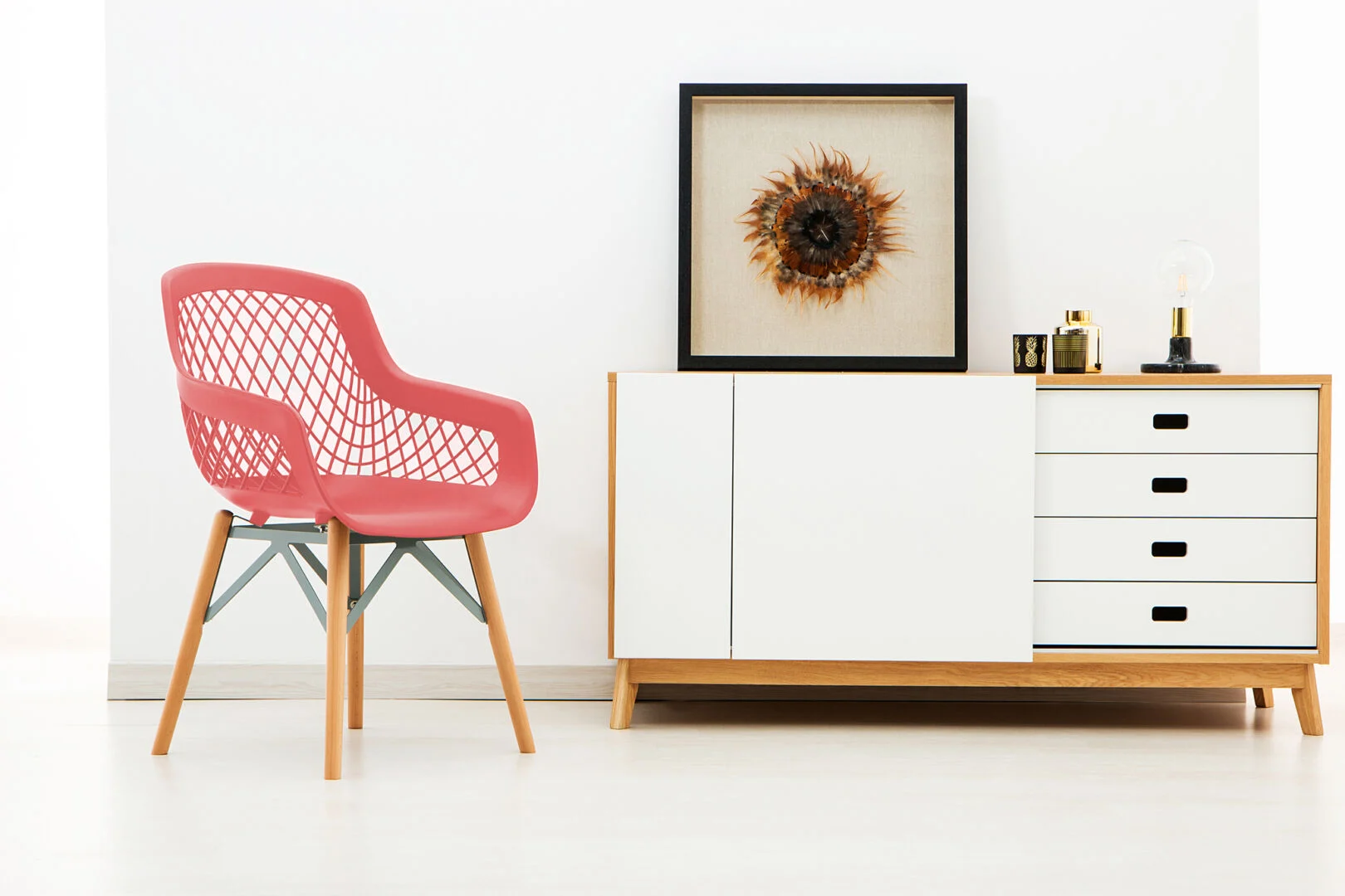 Minimalistische Stoel Rood Set van 4 | Nieuwe Sfeer: Rode design stoel met open rugleuning naast een dressoir.