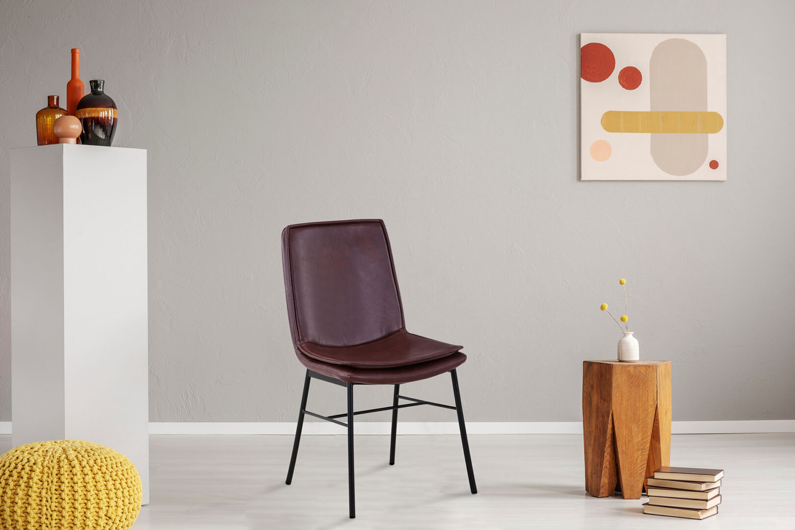 Stoel Brady 100 Marone: Bruine leren stoel met zwart metalen poten in een sfeervolle setting.