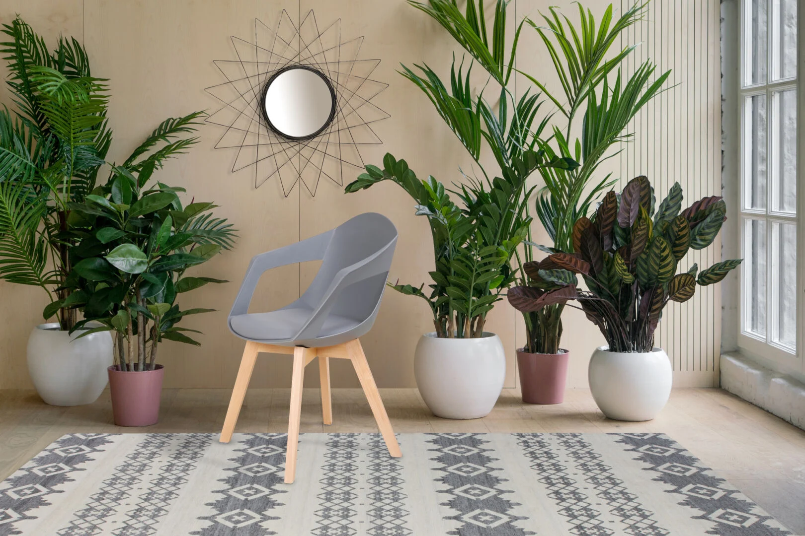 Stoel Chandra Grijs Set van 2 van Nieuwe Sfeer, een grijze stoel in een sfeervolle kamer met planten.