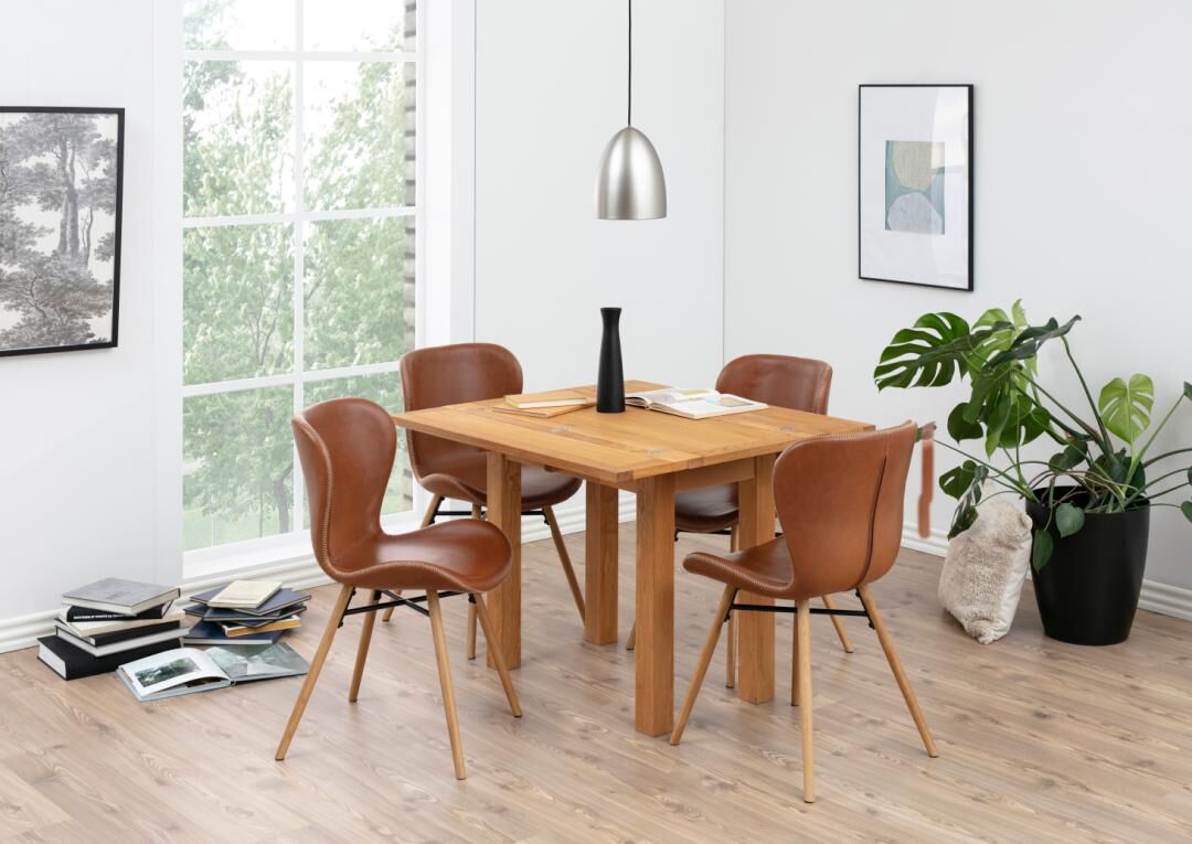 Eetkamer met houten tafel en vier Batilda -A1 eetkamerstoelen (set van 2) in bruin leer.