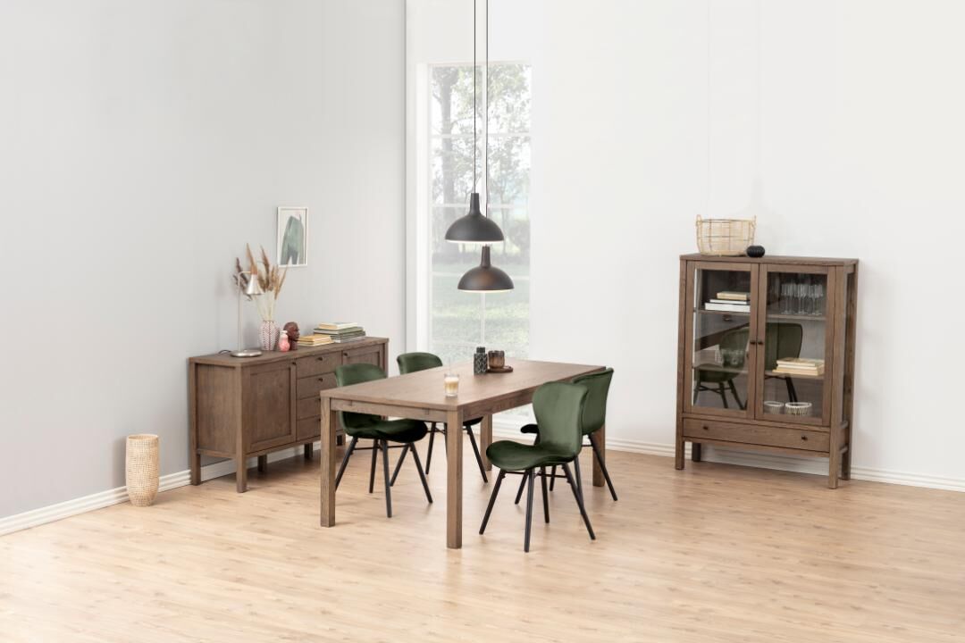 Eetkamer met houten tafel, groene Batilda -A1 eetkamerstoelen, dressoir en vitrinekast.