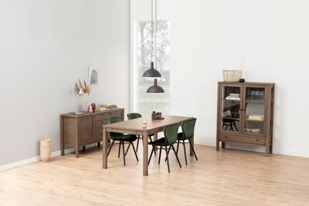 Eetkamer met houten tafel, groene Batilda -A1 eetkamerstoelen, dressoir en vitrinekast.