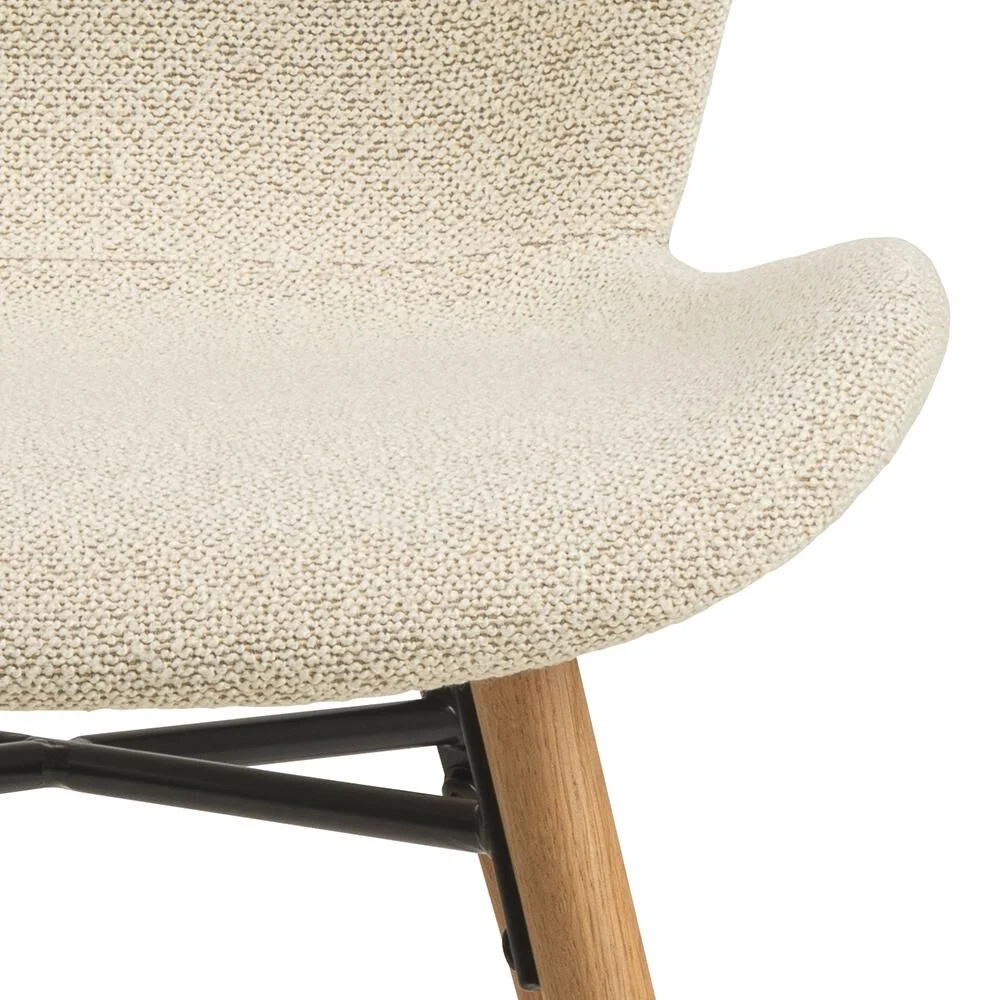 Batilda -A1 eetkamerstoel detail: beige stoffering, houten poten en zwart metalen frame.