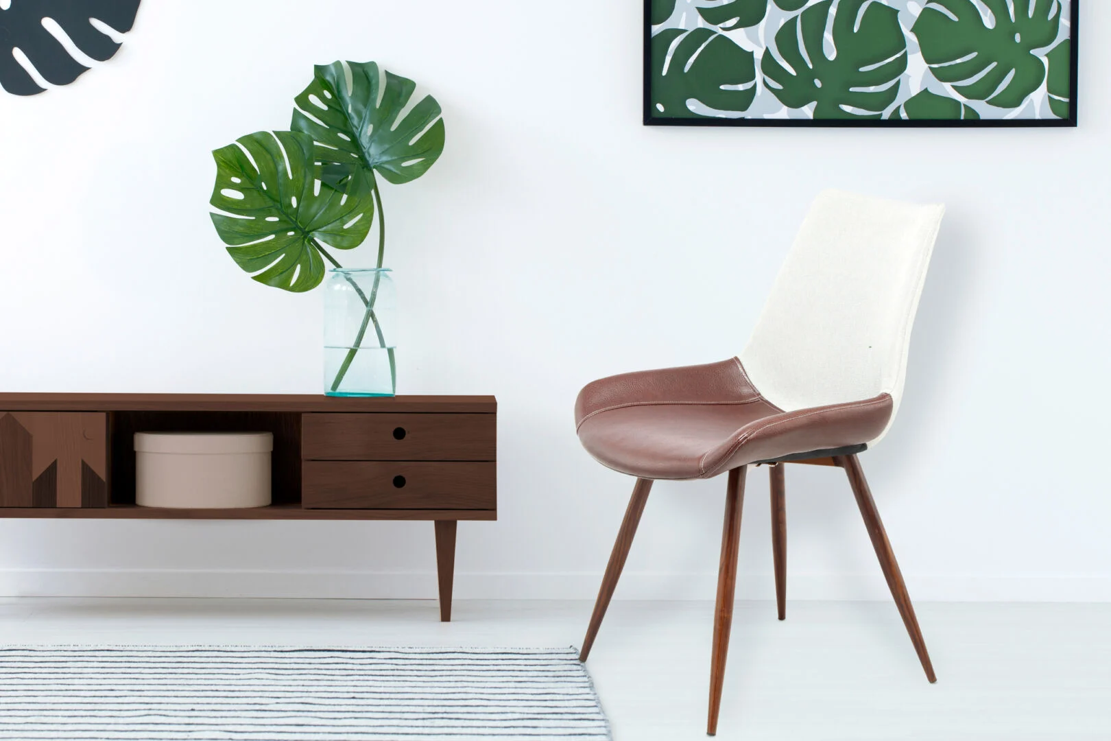 Stoel Evergreen Lichtgrijs Mokka: Bruine leren zitting met witte rugleuning naast houten kast.
