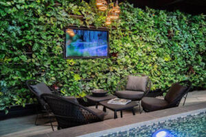 Groene wand met tv, zithoek en zwembad. Sfeervolle groene wanden in een eigentijds interieur.