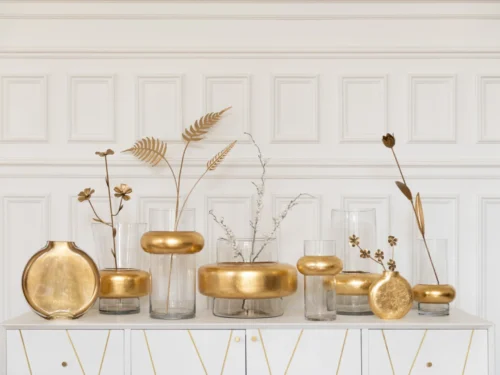 Transparante cilindervormige Vaas Laaskine glas H25 cm met gouden takdecoratie op wit dressoir