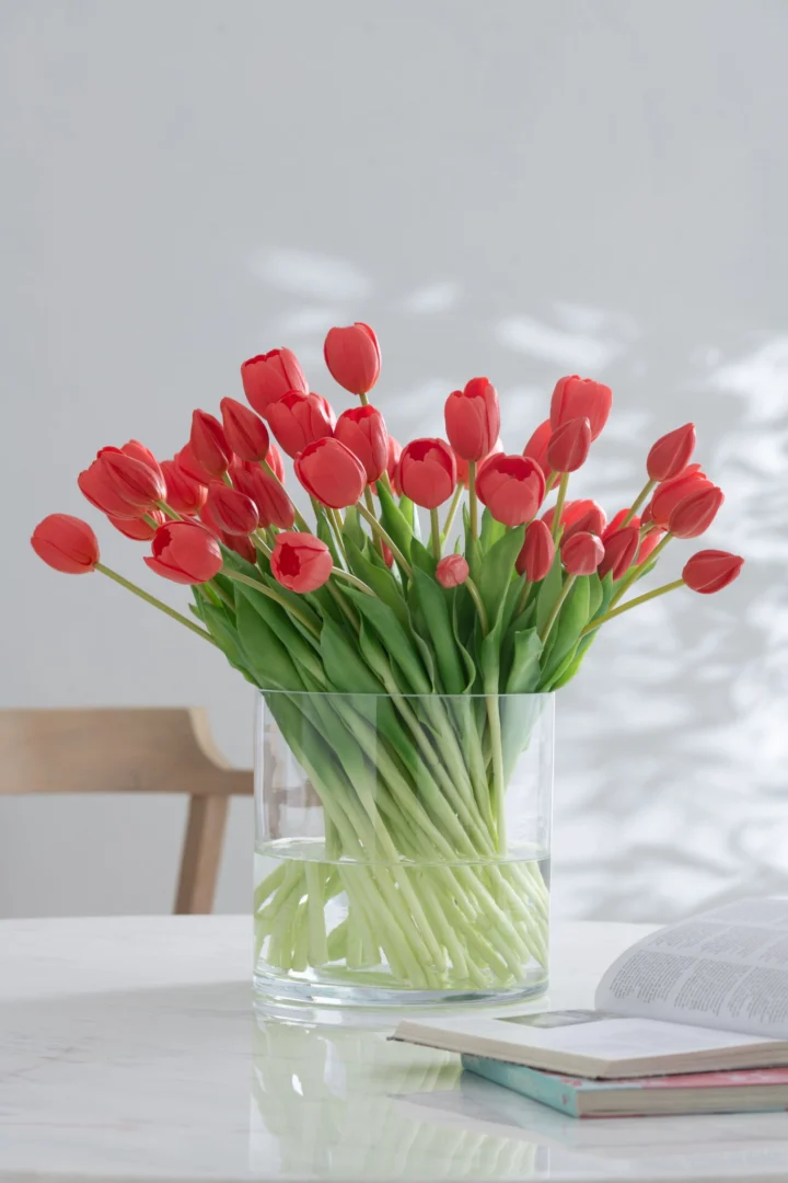 Roze Kunstbloem Meindel van polyurethaan, in een glazen vaas voor een elegante, speelse interieuraccent
