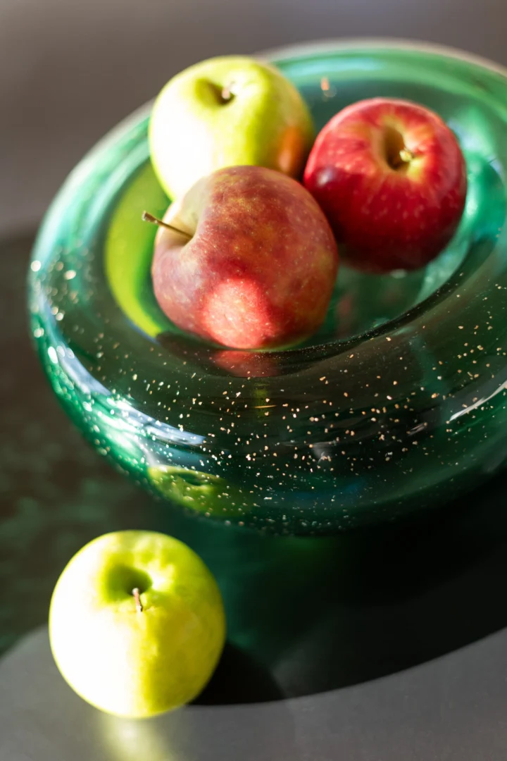Schaal Sleelvon Glas Groen met diepe groene kleur en compact silhouet, gevuld met appels
