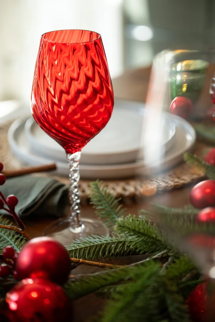 Lavona rood drinkglas met gestreept glas en slanke vorm, stijlvol op een feestelijk gedekte tafel
