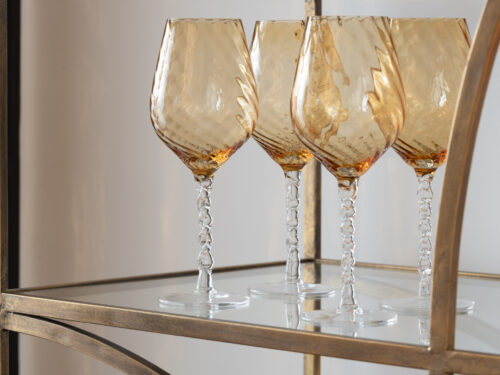 Drinkglas Grosken bruin glas met gestreept design en elegante slanke vorm, vier stuks op een gouden plank