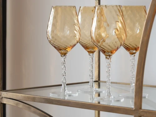 Drinkglas Grosken bruin glas met gestreept design en elegante slanke vorm, vier stuks op een gouden plank