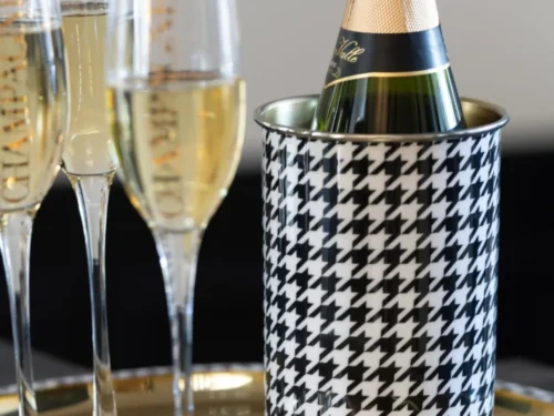 Praalio wijnkoeler goud staal met zwart-wit patroon, gevuld met champagne naast glazen