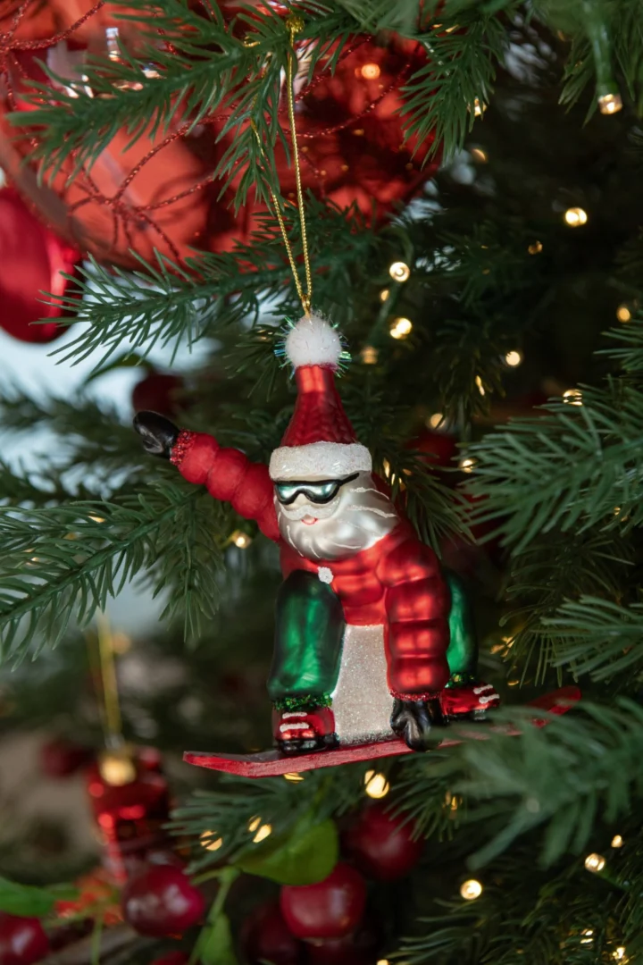 Leeskum kerstdecoratie glas rood: kerstman op snowboard aan een kerstboom met warme lichtjes