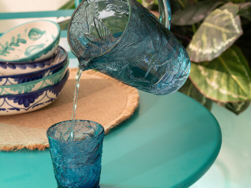 Drinkglas Greeskura blauw, elegant 100% glas met reliëf, gevuld op een turquoise tafel