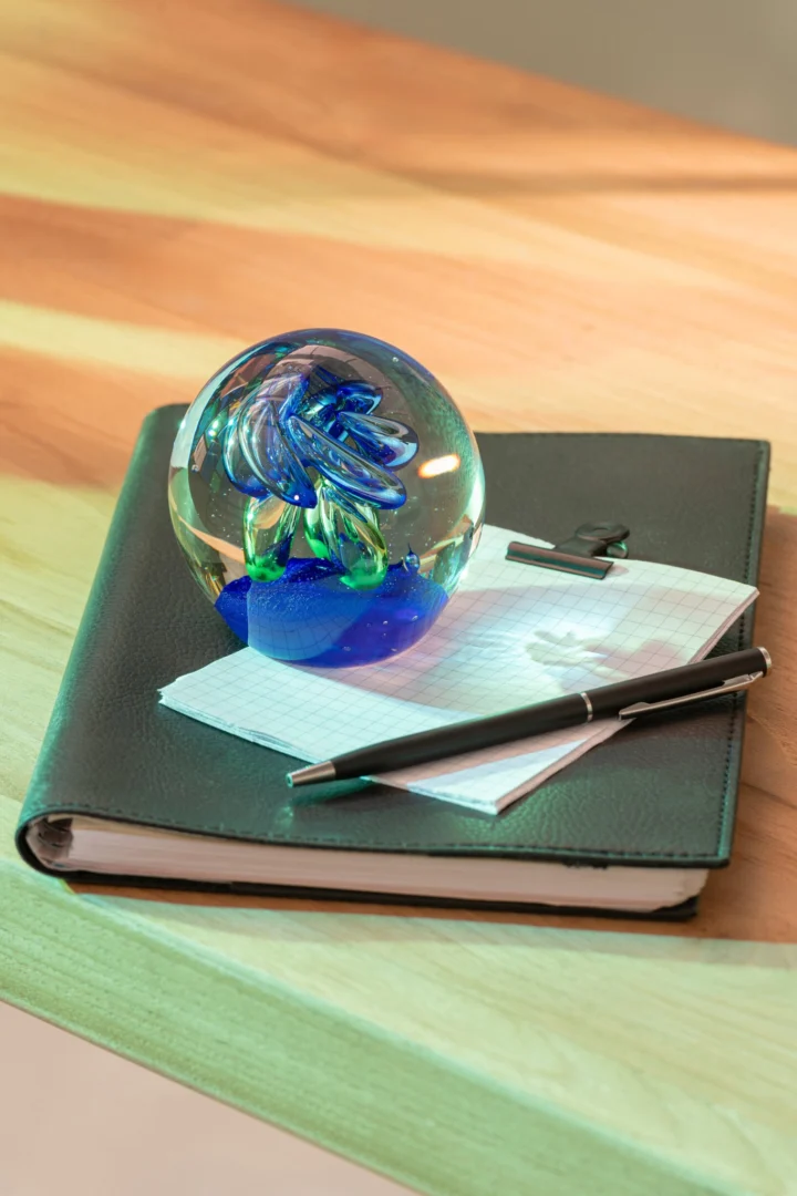 Neerrira glazen presse-papier set van 2 in blauw/groen op notitieboek en bureau, compact en decoratief