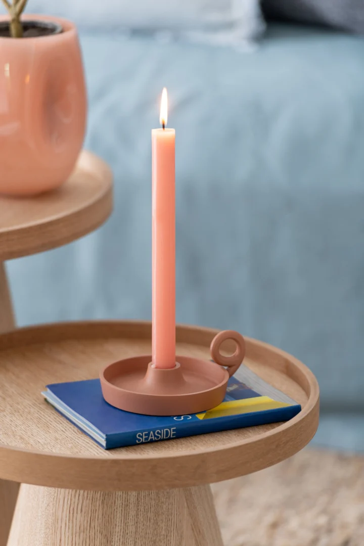 Opbergdoos Trerdio Roze met zachte roze tafelkaars en terracotta houder op houten bijzettafel