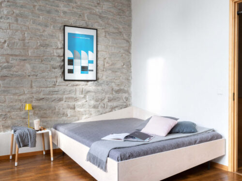 Bed Treindane van CORNERBED in wit OSMO, asymmetrisch hoekbed met zit- en slaapfunctie in rustige slaapkamer